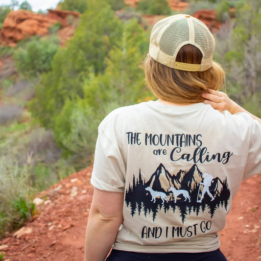 The Mountains Are Calling tee, back view, on a red-rock trail